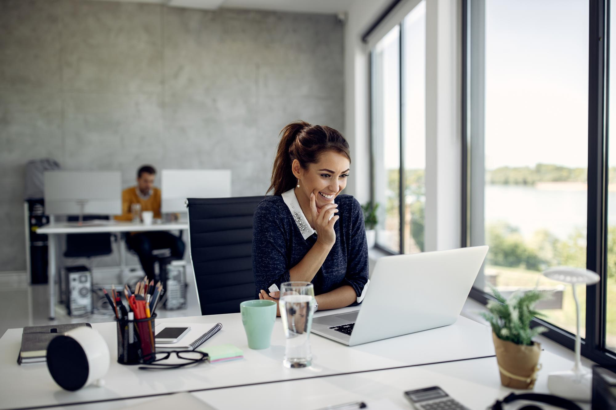 women sitting on her desk happy