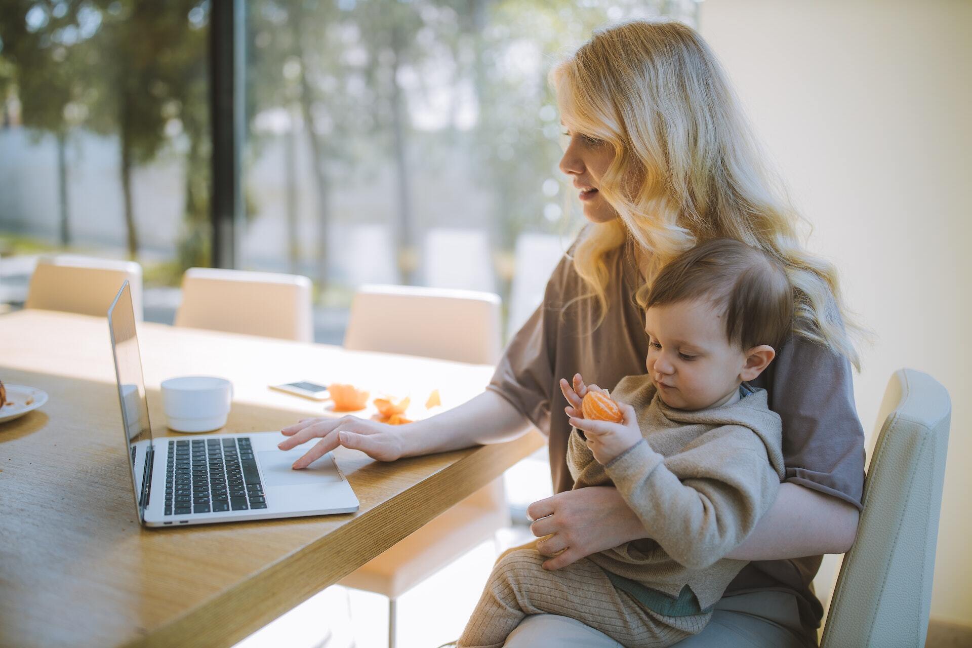 madre trabajando en la oficina en casa con su bebé